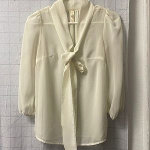 Ivory sheer top with long ties at the neckline.